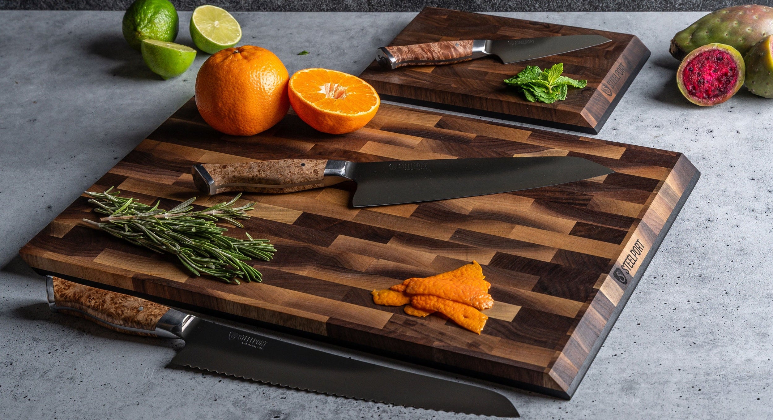 STEELPORT SteelCore™ cutting board with STEELPORT knives and fruits on a gray surface