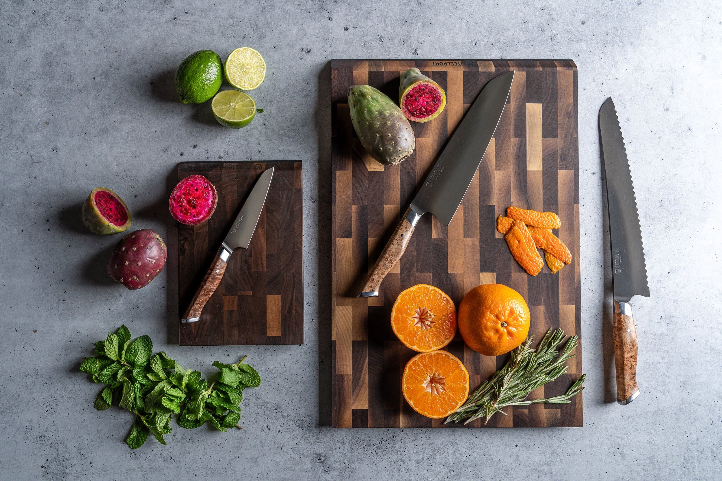 STEELPORT SteelCore™ cutting boards with fruits, vegetables, and STEELPORT knives on a gray surface