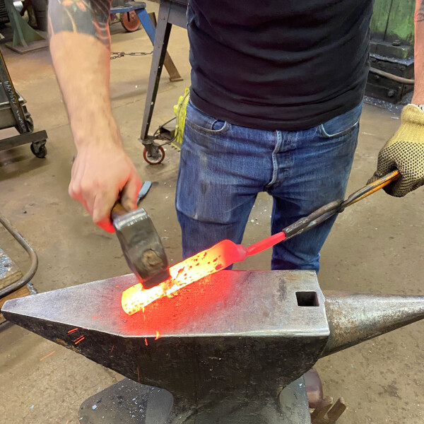 Bladesmith Eytan Zias hammering a carbon steel knife